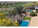 Aerial view of a backyard featuring a beautiful pool, lush desert landscaping, and golf course views at 41910 N Long Cove Way, Anthem, AZ 85086