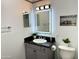 Bathroom featuring modern lighting, grey vanity, sleek black countertop, and a decorative mirror at 4750 N Central Ave # M2, Phoenix, AZ 85012