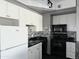 Kitchen featuring white cabinets, black appliances, black countertops, and mosaic backsplash at 4750 N Central Ave # M2, Phoenix, AZ 85012