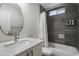 Modern bathroom featuring a sleek vanity, dark tile, shower, and convenient toiletry dispensers at 4904 E Tierra Buena Ln, Scottsdale, AZ 85254