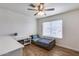 Bright bedroom features a ceiling fan, wood floors, and plenty of natural light from the large window at 5228 W Aster Dr, Glendale, AZ 85304