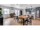 Bright dining room featuring a long wooden table, modern chairs, and an open layout connecting to the kitchen at 5228 W Aster Dr, Glendale, AZ 85304