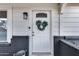 Welcoming front door adorned with a wreath, enhanced by a modern exterior light fixture and stylish brick accents at 5228 W Aster Dr, Glendale, AZ 85304