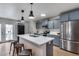 Modern kitchen with stainless steel appliances, sleek countertops, an island with seating, and stylish blue cabinets at 5228 W Aster Dr, Glendale, AZ 85304