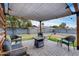 Relaxing patio with a shade cover, a fire pit, and comfortable seating, perfect for outdoor gatherings at 5228 W Aster Dr, Glendale, AZ 85304