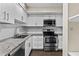 Well-lit kitchen showcasing white cabinets, stainless steel appliances, granite counters and wood floors at 6007 N 79Th St, Scottsdale, AZ 85250
