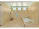 Luxurious bathroom with glass-enclosed shower, soaking tub, tile surround, and natural light from multiple windows at 6125 E Hodges St, Cave Creek, AZ 85331