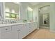 Bright bathroom featuring double sinks, a white quartz countertop, and light-green walls, with tiled floors and mosaic backsplash at 6125 E Hodges St, Cave Creek, AZ 85331