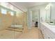 Well-lit bathroom featuring a tiled glass shower, a soaking tub, dual sinks with white cabinets, and views into the vanity area at 6125 E Hodges St, Cave Creek, AZ 85331