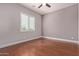 Serene empty bedroom featuring hardwood floors, neutral gray walls, and a bright window, offering a blank canvas at 6125 E Hodges St, Cave Creek, AZ 85331