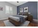 Modern bedroom with a minimalist design, a wooden bed frame, and gray carpet, accentuated by blue and white walls at 6125 E Hodges St, Cave Creek, AZ 85331