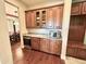 A nook with granite countertops, a wine cooler, and wooden cabinets is shown from the hallway at 6125 E Hodges St, Cave Creek, AZ 85331