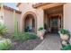 Inviting front porch with stone pavers and decorative flower pots, leading to a wood front door at 6125 E Hodges St, Cave Creek, AZ 85331