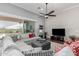 Bright living room with a large sectional sofa, a ceiling fan, and sliding doors to the backyard at 6125 E Hodges St, Cave Creek, AZ 85331