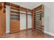 Spacious walk-in closet with custom wood shelving and drawers, offering ample storage space and hardwood flooring at 6125 E Hodges St, Cave Creek, AZ 85331