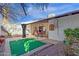 Backyard view with covered patio, putting green and desert landscaping at 6441 E Colby St, Mesa, AZ 85205