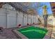 Backyard featuring a small putting green, privacy fence, mature tree and desert landscaping at 6441 E Colby St, Mesa, AZ 85205