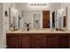 Well-lit bathroom with double vanity, ornate mirrors and a partial view of the toilet and shower area at 6441 E Colby St, Mesa, AZ 85205