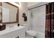 Bathroom with white vanity, decorative mirror, shower over tub with patterned shower curtain at 6441 E Colby St, Mesa, AZ 85205