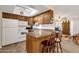 Kitchen with bar stool seating, white appliances, and warm wood cabinets at 6441 E Colby St, Mesa, AZ 85205