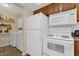 Kitchen appliances including the refrigerator, microwave, and oven next to a washer and dryer at 6441 E Colby St, Mesa, AZ 85205