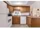 Kitchen featuring white appliances, warm wood cabinets, and laminate countertops at 6441 E Colby St, Mesa, AZ 85205