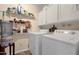 Bright laundry room featuring a washer and dryer with upper and lower cabinets and shelving at 6441 E Colby St, Mesa, AZ 85205