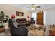 Comfortable living room with reclining chairs, ceiling fan, patterned rug, and an entertainment center at 6441 E Colby St, Mesa, AZ 85205