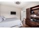 Comfortable bedroom with a built in bookshelf and dark hardwood floors at 6608 W Saguaro Park Ln, Glendale, AZ 85310