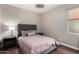 Cozy bedroom featuring a tufted headboard, soft bedding, and natural light at 6608 W Saguaro Park Ln, Glendale, AZ 85310