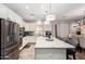 Modern kitchen featuring a large island with seating, stainless steel appliances, and stylish pendant lighting at 6608 W Saguaro Park Ln, Glendale, AZ 85310