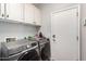 This spacious laundry room features front loading machines and plenty of storage at 6608 W Saguaro Park Ln, Glendale, AZ 85310