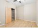 Bedroom with a ceiling fan, wood floors, and closet with shelving at 6777 W Tether Trl, Peoria, AZ 85383