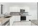 Modern kitchen features stainless steel appliances, granite countertops, and white cabinetry at 6777 W Tether Trl, Peoria, AZ 85383