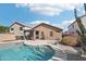 Backyard with a pristine pool, lush desert landscaping, and covered patio at 6777 W Tether Trl, Peoria, AZ 85383