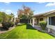 A beautiful backyard features lush grass, mature trees, and a covered patio, ideal for outdoor relaxation at 6920 W Via Montoya Dr, Glendale, AZ 85310