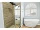 Beautiful bathroom featuring a glass enclosed shower and stand alone tub under a window at 6920 W Via Montoya Dr, Glendale, AZ 85310