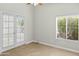 Light bedroom featuring a window and glass patio doors, and a ceiling fan at 6920 W Via Montoya Dr, Glendale, AZ 85310