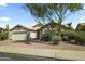 Exterior view of a single-story home with desert landscaping and a two-car garage at 6920 W Via Montoya Dr, Glendale, AZ 85310