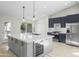 Bright kitchen features a large center island with seating, quartz countertops, wine fridge, and stainless steel appliances at 6920 W Via Montoya Dr, Glendale, AZ 85310