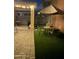 This backyard at night has pavers, green turf, seating, a grill and shade provided by a large umbrella at 7412 E Flower Ave, Mesa, AZ 85208