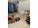Walk-in closet with clothing rack, storage boxes, fan, and shoe rack on a neutral patterned carpet at 7412 E Flower Ave, Mesa, AZ 85208