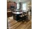 Well-lit kitchen featuring an island with barstool seating, dark cabinetry, and a modern backsplash at 7412 E Flower Ave, Mesa, AZ 85208