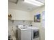 Well-lit laundry room with modern washer and dryer, shelving, and a window for natural light at 7412 E Flower Ave, Mesa, AZ 85208