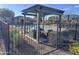 Community pool area featuring shaded lounge seating and well-maintained landscaping, with a wrought iron fence at 7412 E Flower Ave, Mesa, AZ 85208