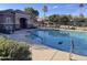 Community pool featuring a splash pad, clubhouse, a desert tree in the water, and plenty of seating at 7412 E Flower Ave, Mesa, AZ 85208