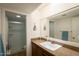 Bathroom featuring a granite vanity, single sink, and glass-enclosed shower, designed for functionality and style at 7755 E Thomas Rd # 17, Scottsdale, AZ 85251