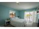 Bright blue bedroom with a bed, a window, and sliding door access to an outdoor terrace or balcony at 7755 E Thomas Rd # 17, Scottsdale, AZ 85251