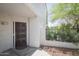 Inviting front entrance featuring a decorative door, complemented by lush greenery and stone landscaping at 7755 E Thomas Rd # 17, Scottsdale, AZ 85251