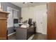 This office features an L-shaped wooden desk, laminate floors and neutral walls at 8221 W Hess Ave, Phoenix, AZ 85043